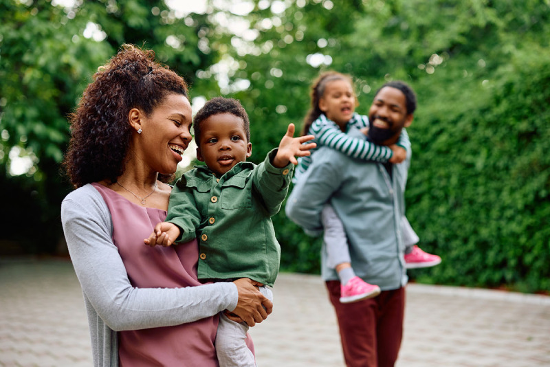Liberty Essential photo of family of four walking along a park path