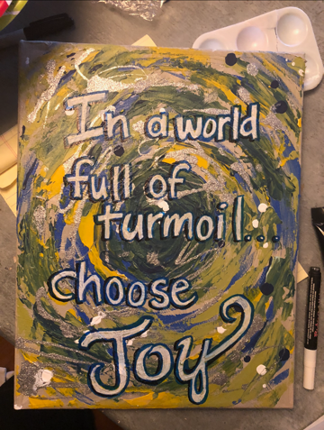 A colorful painting by Carroll reading "In a world full of turmoil...choose joy."