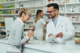 A senior woman picking up her prescription at the pharmacy.