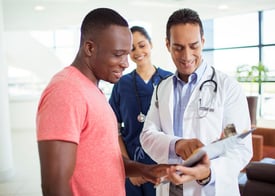 male patient speaking with nurses and a physician about the importance of quality care for the whole family