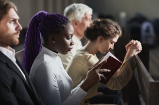 Woman in a church reads about the shepherd staff, lost sheep, and how it relates to spiritual care for families in the world