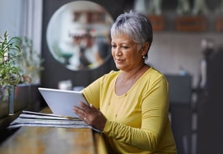 older woman reading about coronary artery disease and general heart disease risk as a major risk factor to develop heart disease