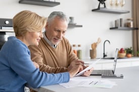 Smiling mature family check their medical bills.