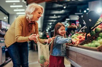woman shopping for fruit with child